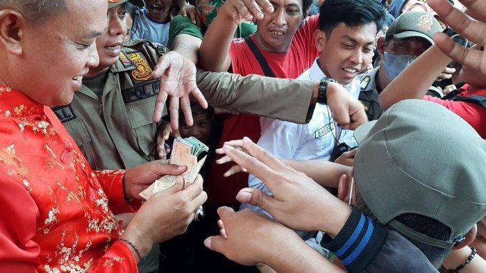 Plt Wali Kota Bekasi bagi-bagi angpao saat meninjau pelaksanaan perayaan Imlek 2575 di Kelenteng Hok Lay Kiong Bekasi, Minggu (22/1/2023).