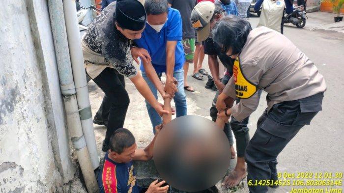 Seorang pria berinisial W (28) dievakausi warga dan petugas usai berusaba ingin mengakhiri hidup di dalam selokan di Jalan Terate RT 009 RW 003, Jembatan Lima, Tambora, Jakarta Barat pada Kamis (8/12/2022).