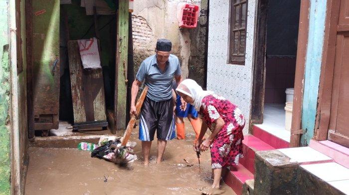 Warga Kebon Pala sibuk membersihkan rumah dari kotoran sisa banjir luapan Kali Ciliwung, Jatinegara, Jakarta Timur, Sabtu (16/7/2022).