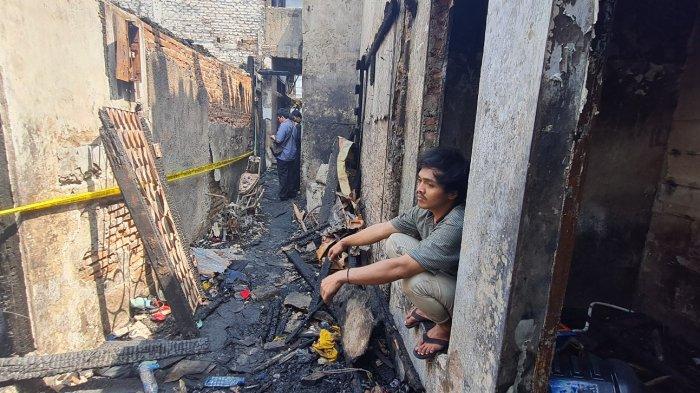 Warga bernama Arif Hidayat (27) duduk termenung meratapi rumahnya hangus terbakar di permukiman padat RT 005 RW 008, Jembatan Besi, Tambora, Jakarta Barat pada Selasa (26/7/2022).