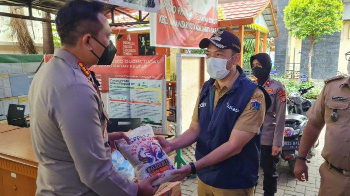 Kapolres Jakarta Barat, Kombes Ady Wibowo memberikan bantuan secara simbolis kepada Lurah Krukut, Ilham Nurkarin di Kantor Lurah Krukut, Jakarta Barat pada Senin (10/1/2022).