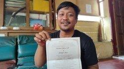 Akhyar Alwi memperlihatkan undangan pernikahannya di Posko Penyaluran Logistik Pramuka, Jl Sultan Hasanuddin, Mamuju, Rabu (20/1/2021) siang