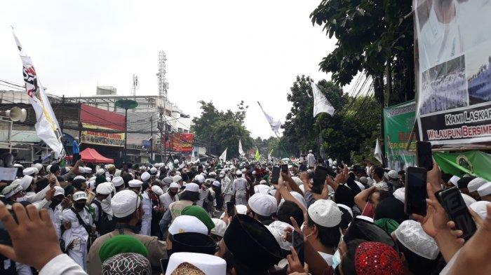 Anggota LPI berusaha mendorong massa yang bersiap menyambut kepulangan Habib Rizieq di Jalan KS Tubun, Petamburan, Tanah Abang, Jakarta Pusat, untuk memberikan jalan kepada mobil rombongan yang melintas, Selasa (10/11/2020).
