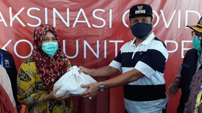 Wali Kota Jakarta Timur Muhammad Anwar saat menyerahkan bingkisan sembako untuk pemulung peserta vaksinasi Covid-19 di Cakung, Sabtu (4/9/2021).