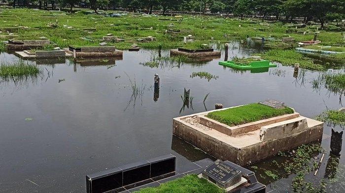 Banjir merendam sejumlah makam yang berada di TPU Semper, Cilincing, Jakarta Utara, Senin (1/2/2021).