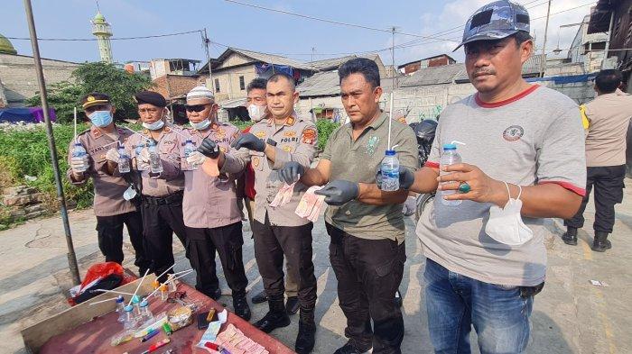 Kapolsek Palmerah, AKP Dodi Abdulrohim bersama jajarannya menunjukkan barang bukti hasil penggerebekan di Kampung Boncos, Palmerah, Jakarta Barat pada Rabu (2/11/2022).