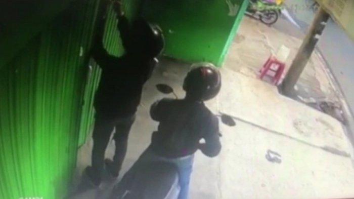 Tangkapan layar pencuri di toko sepeda Jalan Raya Bekasi saat membobol gembok rolling door, Cakung, Jakarta Timur, Jumat (6/8/2021).