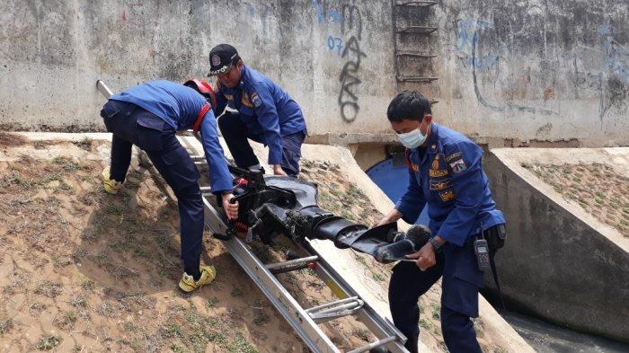 Personel Damkar Jakarta Timur saat menyiapkan motor tempel untuk perahu karet saat latihan evakuasi di Kali Ciliwung, Sabtu (14/11/2020).