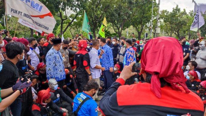 Gubernur DKI Jakarta Anies Baswedan bergaya santai saat menemui massa buruh di depan Balai Kota DKI, Jakarta Pusat.
