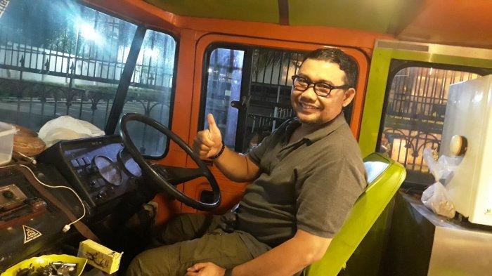 Sosok Hanif Cordova, pemilik Mie Aceh Kring-kring, sedang berpose di belakang kemudi bus Mercy 508D 1984 pada Senin (21/12/2020).
