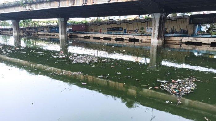 Sampah mencemari Kali Ancol, Pademangan, Jakarta Utara yang volume airnya meningkat akibat hujan deras yang terjadi sejak malam hingga Sabtu (16/7/2022) siang ini.