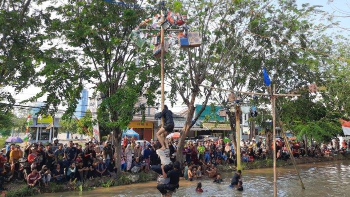 Keseruan lomba panjat pinang di kali warga Kampung Pintu Air Kota Bekasi untuk meriahkan HUT ke-77 Republik Indonesia, Rabu (17/8/2022).
