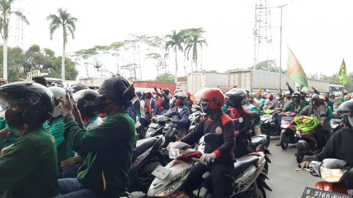 Massa buruh melintas di Jalan Raya Bekasi, Cakung, Jakarta Timur, Kamis (8/10/2020).