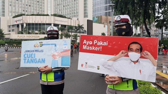 Cuaca mendung menyelimuti masyarakat yang bersepeda dan berjoging di Jalan MH Thamrin, Bundaran Hotel Indonesia (HI), Jakarta Pusat, Minggu (21/2/2021) pagi.