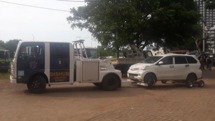 Sebuah mobil yang diderek petugas Dishub saat tiba di Kantor Sudinhub Jakarta Barat, Rabu (20/3/2019).