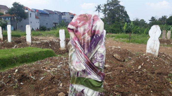 Sejumlah nisan Covid-19 diikat dengan kerudung, peci atau pita sebagai tanda di TPU Srengseng Sawah, Jagakarsa, Jakarta Selatan pada Kamis (27/5/2021).