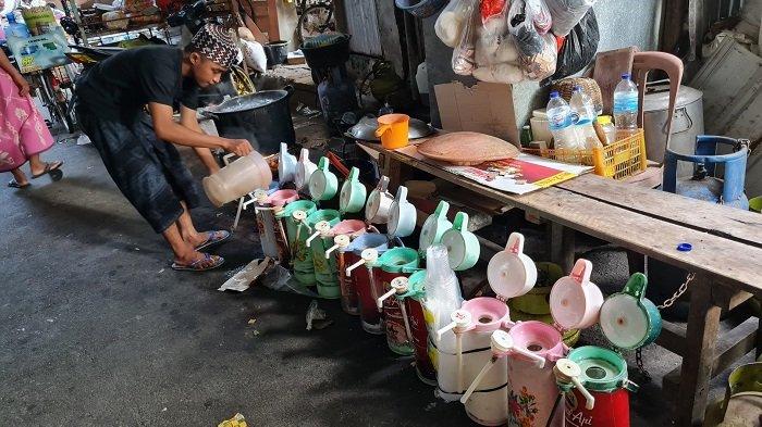 Pedagang menuang air panas ke dalam deretan termos di Kampung Starling di Senen, Jakarta Pusat pada Rabu (22/9/2021).