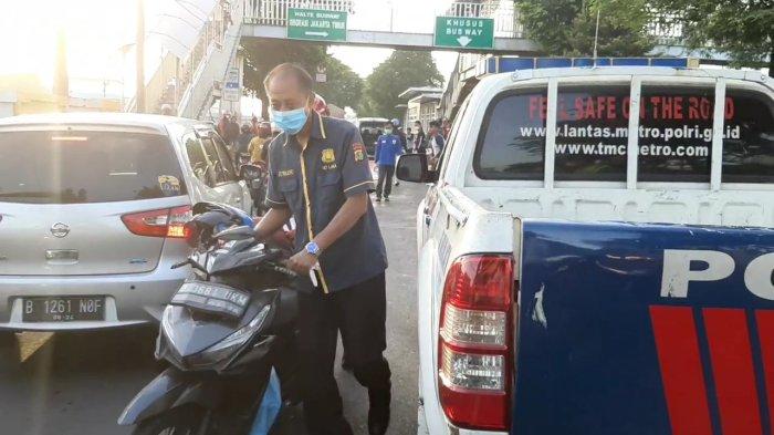 Personel Unit Laka Satlantas Jakarta Timur saat mengamankan sepeda motor dikemudikan Rustandi sebagai barang bukti, Jatinegara, Jakarta Timur Senin (4/7/2022). Pemotor tewas akibat kecelakaan jalan bergelombang di Jatinegara.