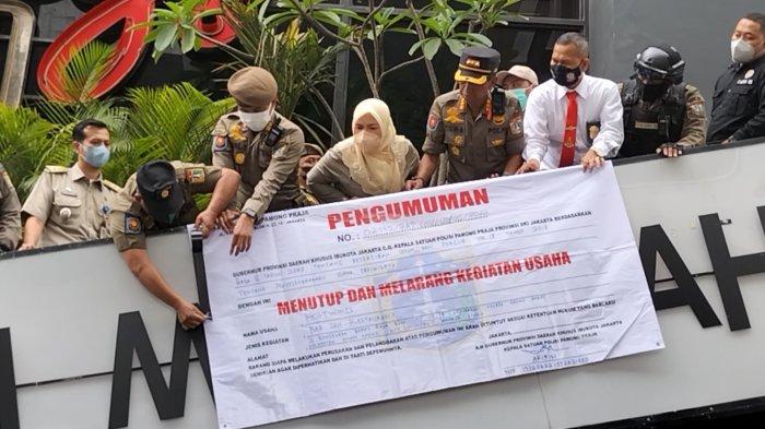 Petugas Satpol PP menyegel Holywings Gold di Jalan Boulevard Barat Raya, Kelapa Gading, Jakarta Utara, Selasa (28/6/2022).