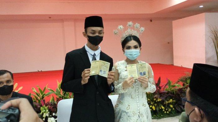 MS (19), tersangka mahasiswi pembuangan bayi dan kekasihnya, NL, menunjukan buku nikah usai pernikahan di kantor Polres Metro Jakarta Timur, Kamis (7/7/2022).