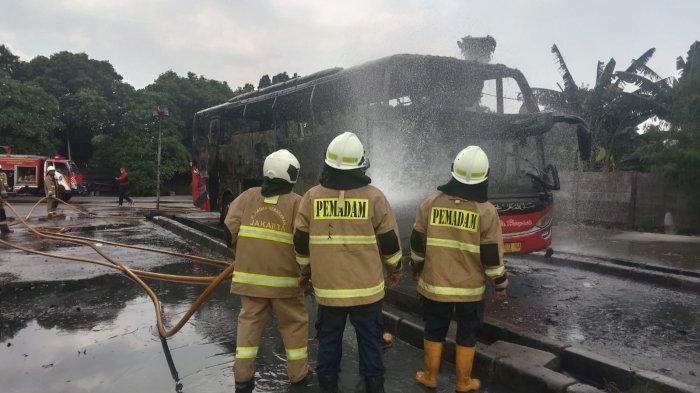 Personel Damkar Jakarta Timur saat pemadaman api bus AKAP di Terminal Pulogebang yang terbakar, Rabu (6/4/2022).