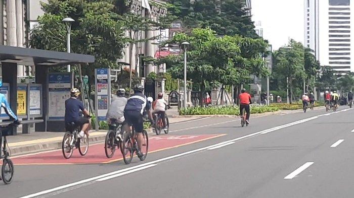 Pesepeda menggowes santai sepedanya, di sepanjang Jalan Sudirman hingga Bundaran Hotel Indonesia, MH Thamrin, Jakarta Pusat, Minggu (13/12/2020) pagi.