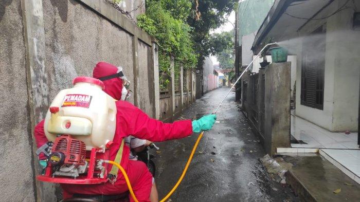 Personel Damkar Jakarta Timur saat melakukan proses penyemprotan disinfektan di permukiman warga, Minggu (31/1/2021).