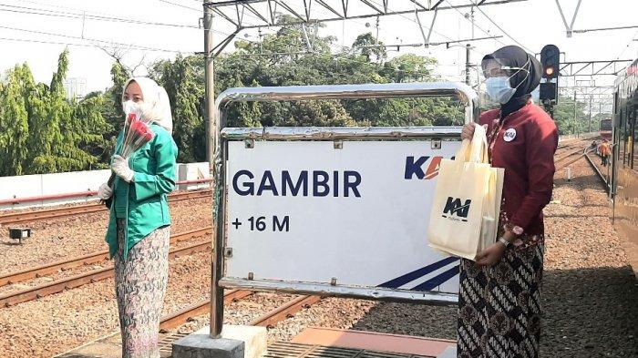 Petugas memberikan bunga mawar kepada penumpang kereta di rangkaian kereta api, Stasiun Gambir, Jakarta Pusat, Rabu (21/4/2021).