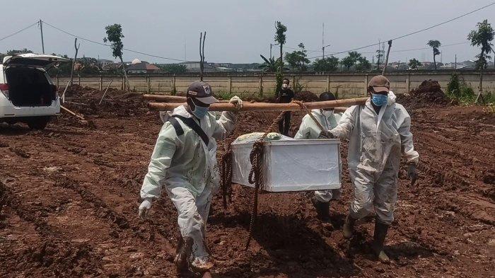 Petugas mengangkut peti jenazah Covid-19 menggunakan bambu di TPU Rorotan, Cilincing, Jakarta Utara, Rabu (16/2/2022). Kasus Covid-19 yang meningkat sejak akhir Januari disusul peningkatan angka kematian harian sehingga TPU Rorotan kembali diramaikan mobil ambulans pada pertengahan Februari.