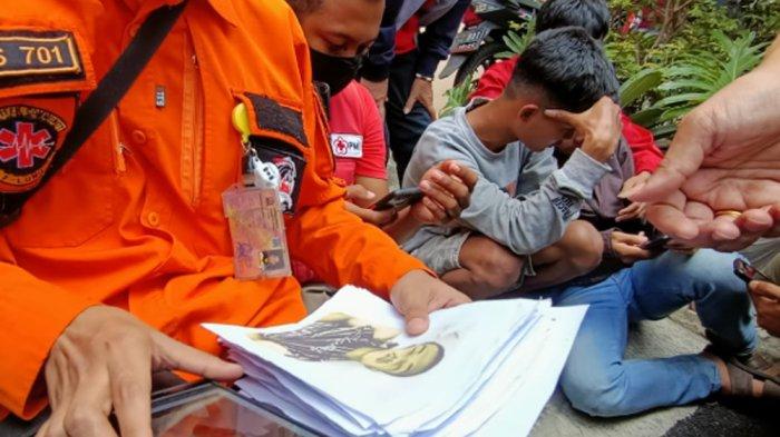 Petugas mengecek foto-foto korban Tragedi Kanjuruhan pascalaga Arema VS Persebaya untuk diperlihatkan kepada keluarga yang sedang mencari anggota keluarganya di salah satu rumah sakit di Malang, Minggu (2/10/2022).