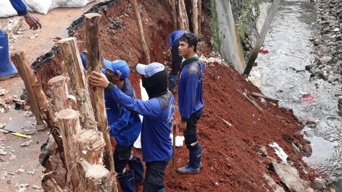 Personel Sudin SDA Satpel Kecamatan Kramat Jati saat proses penanganan turap saluran PHB Kali Induk yang longsor, Senin (22/2/2021).