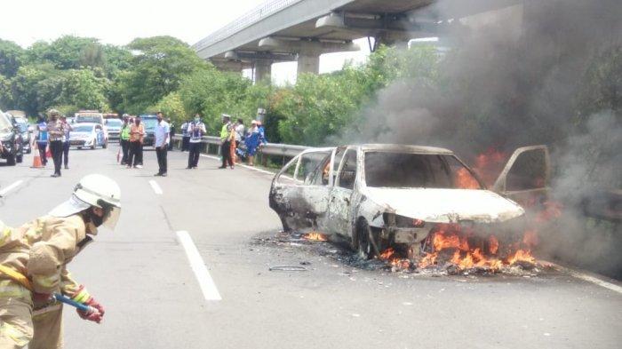 Personel Sudin PKP Jakarta Timur saat proses pemadaman api di mobil yang terbakar di Tol Jagorawi, Senin (5/10/2020)