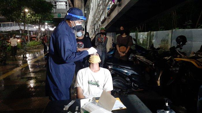 Sejumlah remaja yang terjaring razia protokol kesehatan saat berkumpul di bawah jembatan penyebrangan orang (JPO) Dukuh Atas, Setiabudi, Jakarta Selatan, Jumat (5/2/2021) malam.
