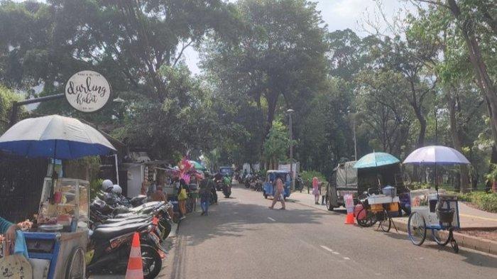 Sejumlah pedagang kaki lima (PKL) berjualan dan kendaraan parkir liar di sekitar luar Tebet Eco Park tepatnya sisi Jalan Tebet Barat, Jakarta Selatan, Senin (13/6/2022) siang.