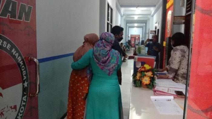 Siswi SD, Mawar (13), memakai baju oranye saat digandeng ibunya mendatangi Satreskrim Polresta Malang Kota, pada Senin (22/11/2021) sore.