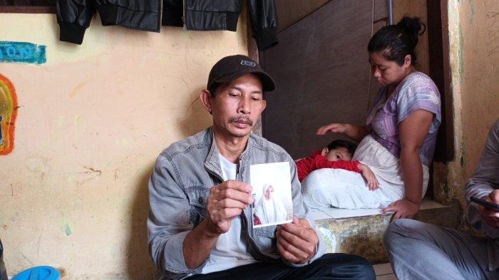 Agus Supriyadi (45), menunjukkan foto putrinya, Resma Novita (16), siswi kelas X SMKN 51 Jakarta, yang hilang usai pamit dari rumah untuk berangkat sekolah di Cipayung, Jakarta Timur, saat ditemui di kediaman, Minggu (15/5/2022).