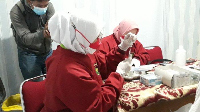 Tim vaksinator RS Polri Kramat Jati saat menunjukkan vial vaksin Covid-19 jenis Moderna saat penyuntikan warga umum, Jakarta Timur, Selasa (17/8/2021).