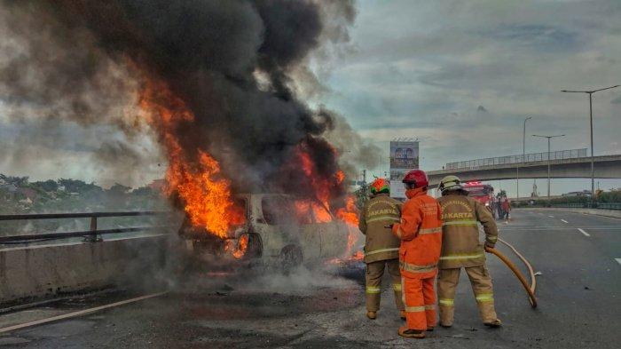 Petugas Damkar Jakarta Timur berusaha memadamkan kebakaran yang menimpa mobil Toyota Land Curiser di Jalan Tol Wiyoto Wiyono, Jatinegara, Jakarta Timur, Senin (22/11/2021).
