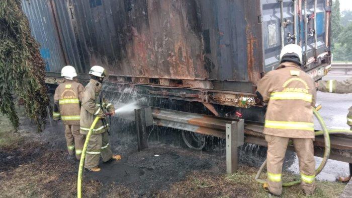 Petugas Damkar Jakarta Timur berusaha memadamkan api di truk kontainer yang terbakar di Tol JORR KM 53,600, Cakung Barat, Cakung, Jakarta Timur, Rabu (15/6/2022) pagi. Kebakaran diduga dipicu pecah ban.