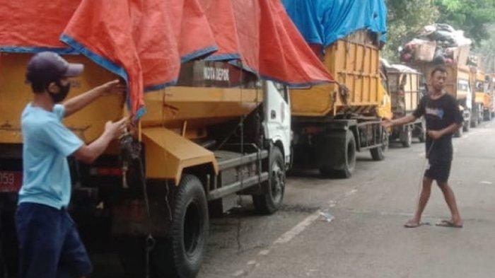 Sejumlah truk pengangkut sampah mengantre setelah akses jalan menuju Tempat Pembuangan Akhir (TPA) Cipayung Kota Depok, tertutup longsoran dari gunungan sampah.