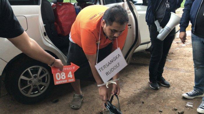 Tersangka pembunuhan Rudolf saat memeragakan adegan pembuangan mayat korban bernama Icha di Kalimalang bawah Tol Becakayu, Rabu (7/12/2022).