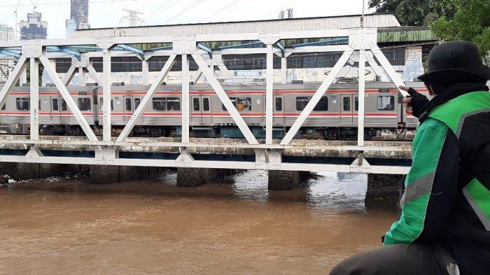 Warga setempat menanti kemunculan ular di dekat antara Pintu Air Karet dan Rumah Susun Petamburan, Kecamatan Tanah Abang, Jakarta Pusat, Selasa (9/2/2021).
