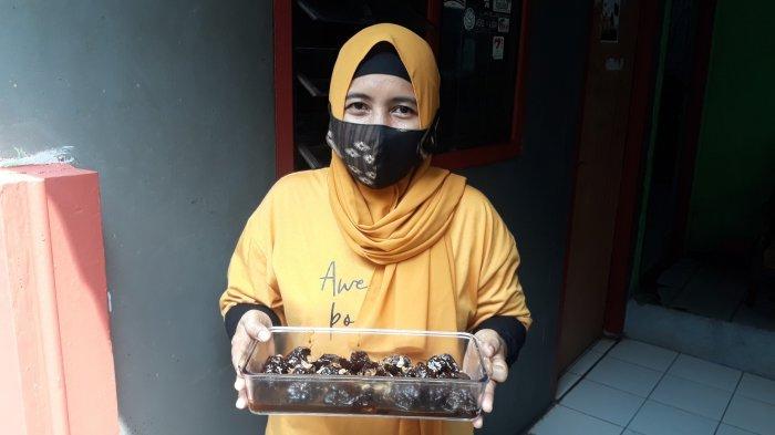 Warga Lenteng Agung RT 004 RW 008, Purwanti (40) memegang semur kerbau andil hasil buatannya kepada TribunJakarta.com pada Rabu (12/5/2021).