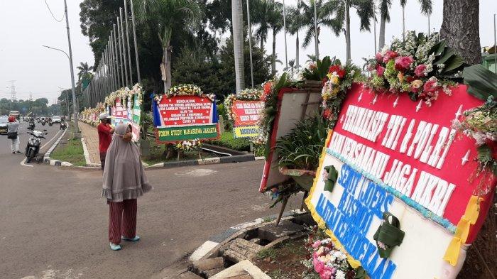 Yanto dan Yati melihat jajaran karangan bunga di depan Makodam Jaya, Kramat Jati, Jakarta Timur, Senin (23/11/2020).