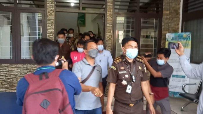 Subhi memakai rompi merah saat akan dibawa ke mobil tahanan