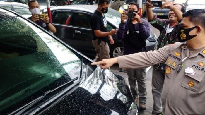 Kapolresta Solo Kombes Pol Ade Safri Simanjuntak menunjukan bagian mobil Toyota Alphard yang bolong karena tertembak di Jalan Monginsidi Solo, Rabu (2/11/2020).