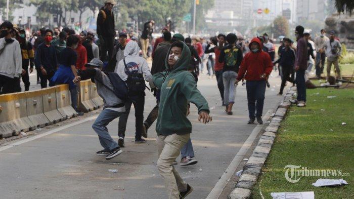Pengunjukrasa yang berasal dari buruh, mahasiswa, dan pelajar terlibat bentrok dengan polisi saat unjuk rasa di sekitar Patung Kuda Jakarta, Kamis (8/10/2020). Mereka menuntut pemerintah untuk membatalkan UU Cipta Kerja yang dinilai memberatkan pekerja.