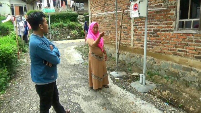 Uminingsih, Ketua RT 07, RW 04, Desa Majakerta, Kecamatan Watukumpul, Pemalang, berdiri di sebelah satu dari dua EWS, yang dipasang di desa, Selasa (6/4/2021).