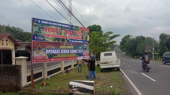Jajaran Satlantas Polres Wonogiri melakukan pemasangan baliho berisi imbauan berlalu lintas di Jalan Raya Wonogiri-Ngadirojo Bulusulur Kecamatan/Kabupaten Wonogiri, Kamis (18/11/2021).