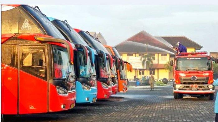 Petugas Damkar Boyolali ketika melalukan penyemprotan kepada 5 armada bus yang ditumpangi Paguyuban Pedagang Pasar Cepogo di Asrama Haji Donohudan Boyolali, Selasa (2/2/2021).